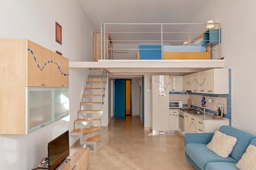 a small apartment with a blue couch and a loft bed at Luminosity by the sea in Calambrone