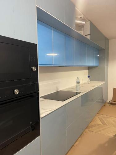 a kitchen with a sink and blue cabinets at Pavillon sur cour . in Paris