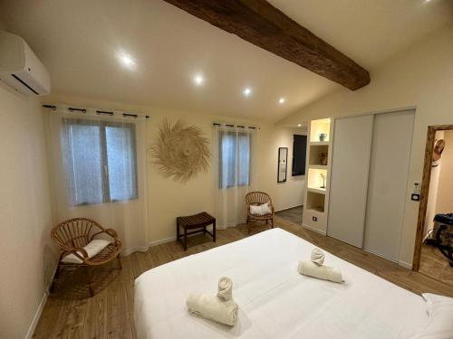 阿爾勒的住宿－La Tapie de Bouchet，卧室配有一张白色大床和两把椅子