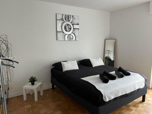 - une chambre avec un lit noir et blanc dans l'établissement Travel homes spacieux et paisible parking privé, à Illzach
