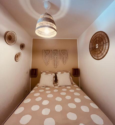 Ce lit se trouve dans une chambre dotée d'un lustre. dans l'établissement L’appart de la Plage, à Saintes-Maries-de-la-Mer