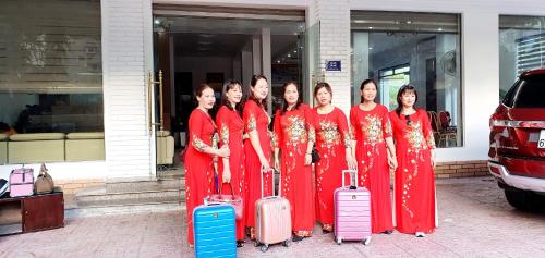 a group of women standing in front of a building with luggage at Khách Sạn Hoàng Nam-Cửa Lò-Nghệ An in Thương Xà (2)