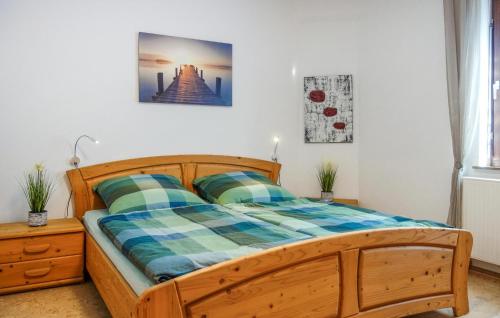 a bedroom with a wooden bed with a plaid blanket at 2 Bedroom Gorgeous Apartment In Finnentrop in Finnentrop