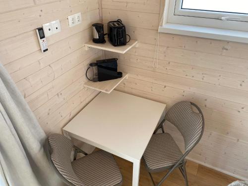 ein Tisch und zwei Stühle in einem winzigen Raum in der Unterkunft Ugla Gistihús (Ugla Guesthouse) in Hella