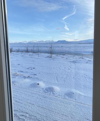 a view of a snow covered field from a window at Ugla Gistihús (Ugla Guesthouse) in Hella