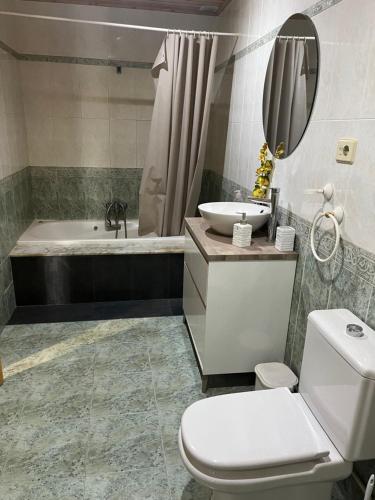 La salle de bains est pourvue d'une baignoire, de toilettes et d'un lavabo. dans l'établissement Apartamento vacacional en O Grove, à O Grove