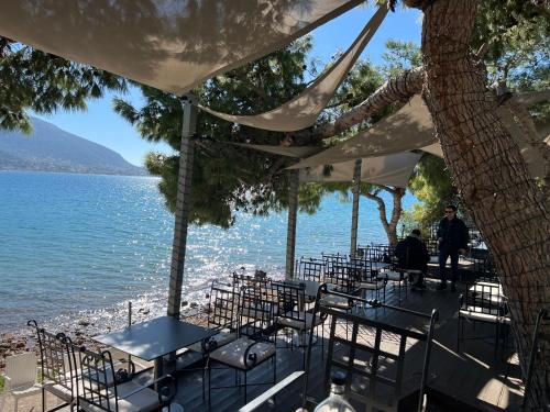 a group of tables and chairs next to the water at ALTAVILLAS maisonettes in Kakí Vígla