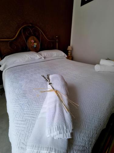 a white blanket on a bed with a wooden headboard at Borgo Scorciarini B&B in Piedimonte Matese