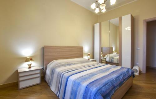 a bedroom with a large bed with a blue blanket at Lovely Home In Linguaglossa With Wifi in Linguaglossa