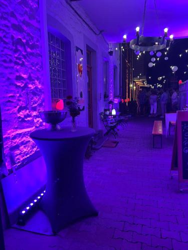 a room with purple lights and a stone wall at Hotel-Restaurant Zum Onkel Jonathan in Raeren