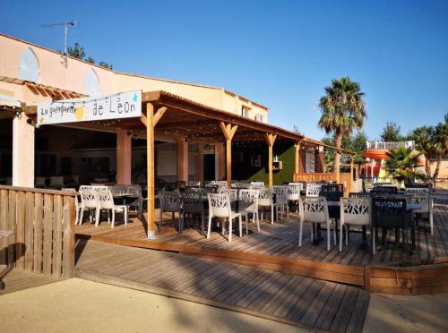 a restaurant with tables and chairs on a deck at Mobilhome cosy tout confort 6-8 personnes in Valras-Plage