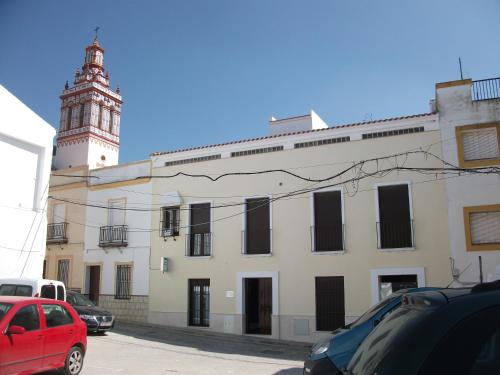 un bâtiment avec une tour d'horloge et une voiture rouge dans l'établissement Andalucía Central, à Fuentes de Andalucía