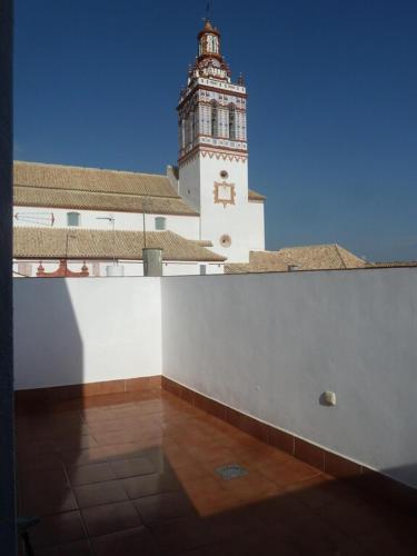 un grand bâtiment avec une tour d'horloge en arrière-plan dans l'établissement Andalucía Central, à Fuentes de Andalucía
