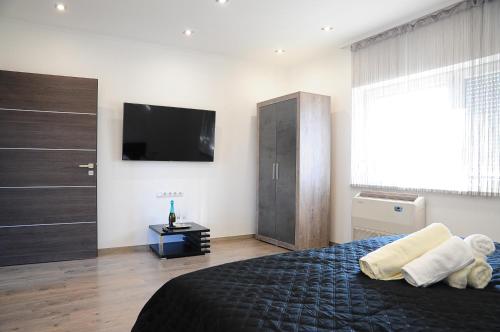 ein Schlafzimmer mit einem großen Bett und einem TV an der Wand in der Unterkunft M Art Inn Apartman in Soltvadkert