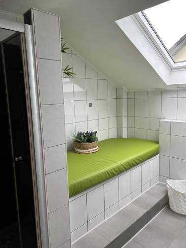 ニデッケンにあるFerienwohnung Beckerの壁に緑のベンチが備わる部屋