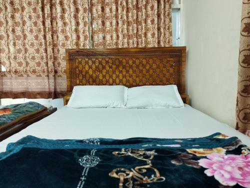 a bedroom with a bed with a blanket on it at New Hotel Labbaik 3 in Dhaka