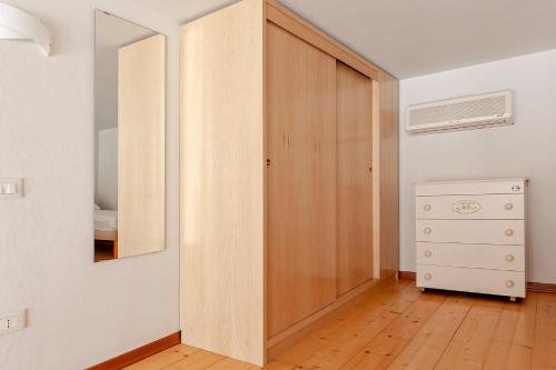a room with a closet with a mirror and a dresser at Luminosity by the sea in Calambrone