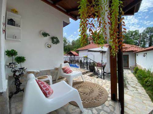 patio con tavolo e sedie bianche di Къща за гости Casa Per Te a Marchevo