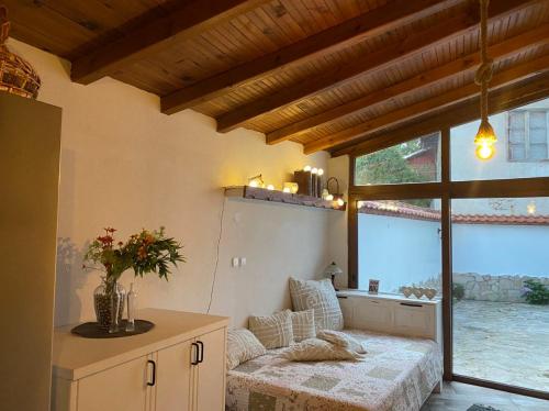 a living room with a couch and a large window at Къща за гости Casa Per Te село Огняново - село Марчево in Marchevo