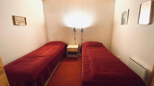 a small room with two beds and a lamp at Arctica in Saariselka