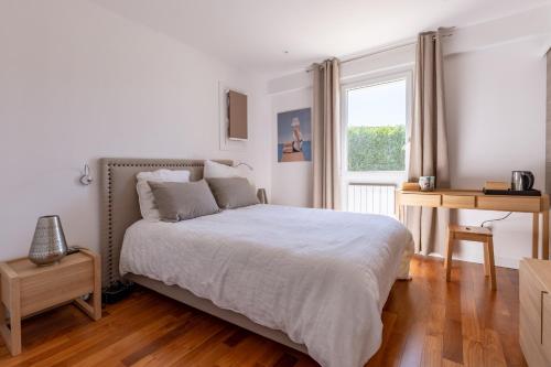 une chambre blanche avec un lit et une fenêtre dans l'établissement Villa Kate, Villa moderne, 5 ch. accès privé à la plage, à Grimaud
