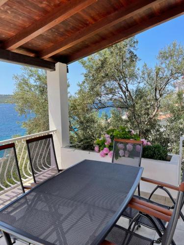 einen Tisch auf einem Balkon mit Blick auf das Wasser in der Unterkunft Apartment Val in Kaprije