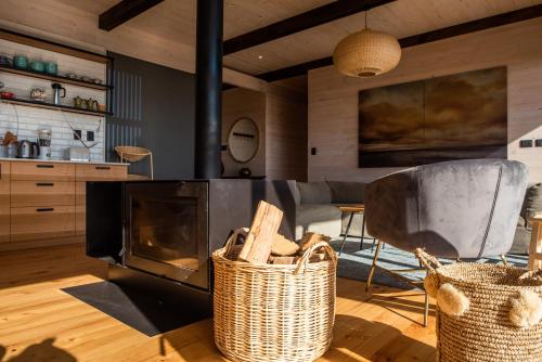 a living room with a fireplace and two baskets at Espectacular Casa Palafito frente al mar in Pichilemu
