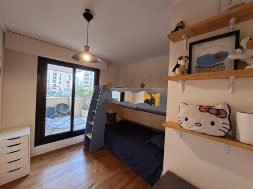 - une chambre avec des lits superposés et une fenêtre dans l'établissement Superbe appartement 3 pièces 57 m2 avec Terrasse 33m2, à Levallois-Perret