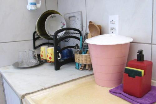 a kitchen counter with a sink and some dishes at Casa praiana - agradável e confortável ambiente com ar-condicionado in Parnaíba