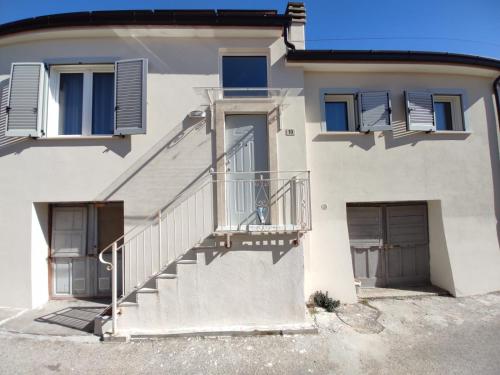 a white house with a staircase and two doors at Tra i Parchi in Pescina