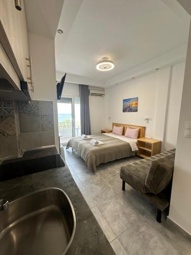 a bathroom with a bed and a tub in a room at Ammos Hotel in Agia Triada