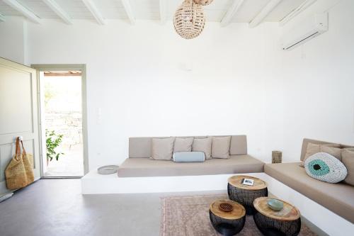 VILLA AMBROSIA في Khálara: غرفة معيشة بيضاء مع أريكة وطاولتين
