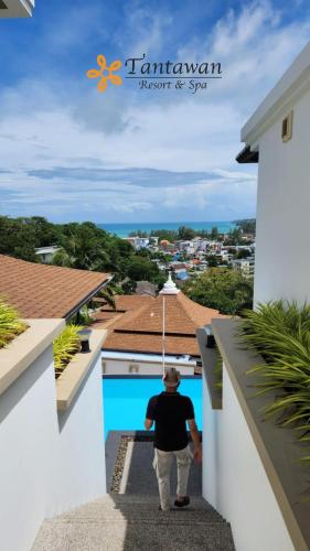 a man walking down the stairs of a house at Villa Tantawan Resort - Private Pool Villas in Kamala Beach