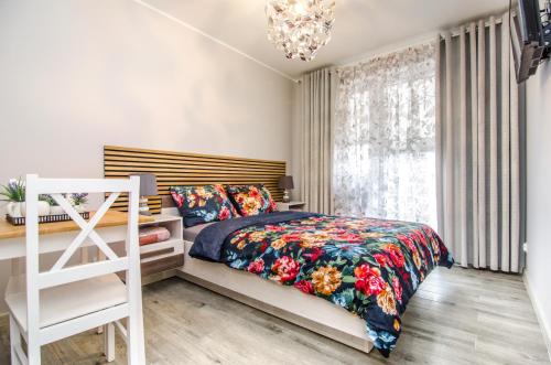 a bedroom with a bed and a chandelier at Willa Anavill in Mielno