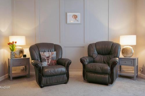 Duas cadeiras numa sala de estar com dois candeeiros em Modern 3 Bedroom home. A perfect base for Golfers em Ladybank
