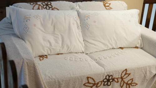 uma cama com 3 almofadas e um edredão branco em Pigneto liberty house em Roma