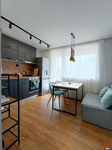 a kitchen and a living room with a table and a couch at Кокетен апартамент VeRa Suite in Silistra