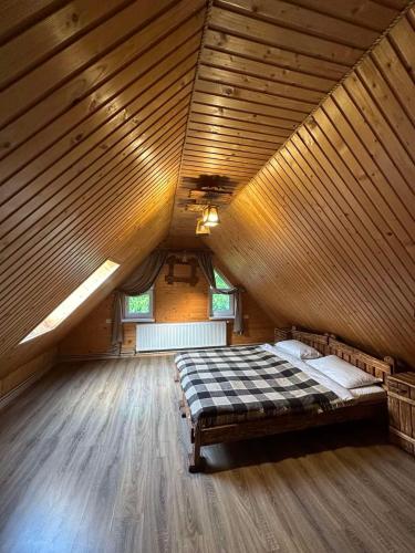 a large room with a bed in a wooden ceiling at Писанка in Yaremche
