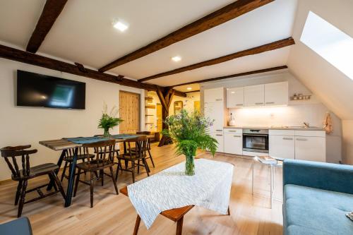 a kitchen and living room with a table and chairs at Penzion Pod hradem in Adršpach