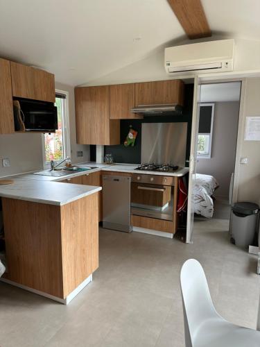 une cuisine avec un évier et une cuisinière four supérieur dans l'établissement Mobile home, aux Mathes