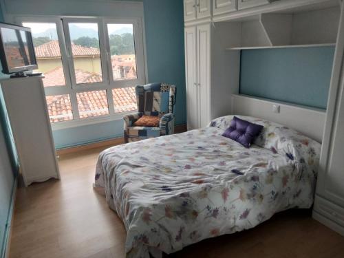 リャネスにあるLlanesのベッドルーム1室(紫色の枕が付いたベッド1台付)