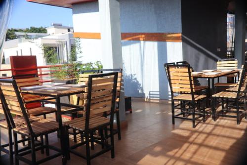 un restaurante con mesas y sillas en un patio en Zeyman’s Appartments, en Kigali