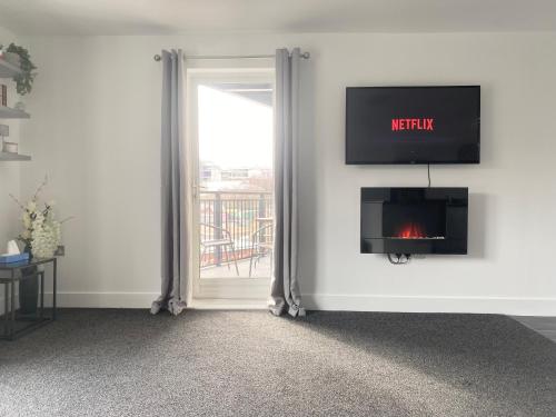 a living room with a fireplace and a window at Luxury Apartment with Balcony in Dewsbury