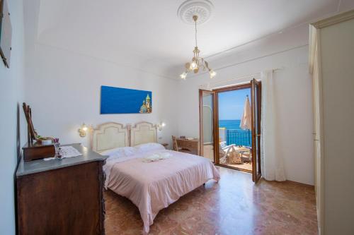 1 dormitorio con 1 cama, vestidor y ventana en CASA OLGA, UN AFFACCIO SUL MARE !!, en Praiano