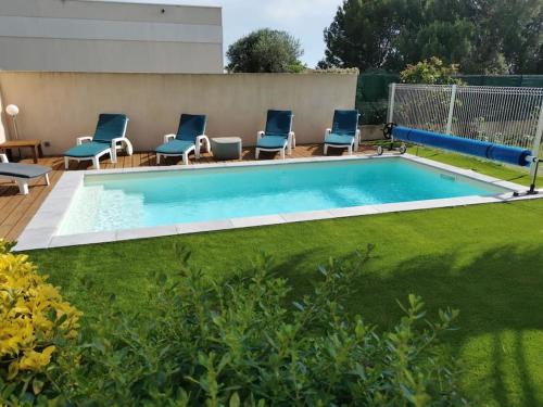 - une petite piscine avec des chaises dans la cour dans l'établissement A 5min des plages La Villa Sun Piscine chauffée, à Vendres
