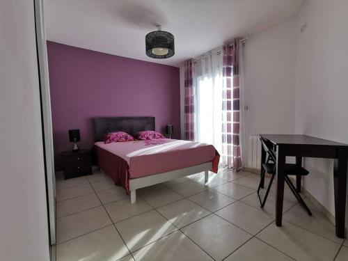 - une chambre avec des murs violets, un lit et un bureau dans l'établissement A 5min des plages La Villa Sun Piscine chauffée, à Vendres