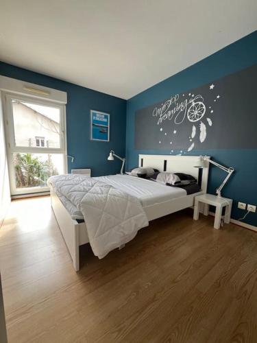 une chambre avec un lit et un mur bleu dans l'établissement Maison Duplex T4 6 couchages, à Gujan-Mestras