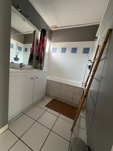 une salle de bain avec une baignoire, un lavabo et un miroir dans l'établissement Maison Duplex T4 6 couchages, à Gujan-Mestras