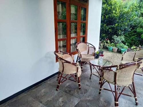 a group of chairs and a table on a patio at Stream Home in Haputale