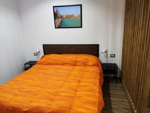 Un dormitorio con una cama grande con una manta naranja. en New Malù apartment, en Bari
